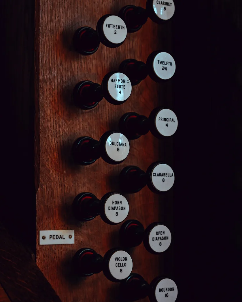 Panel de madera con tiradores de registro rotulados de un órgano de tubos